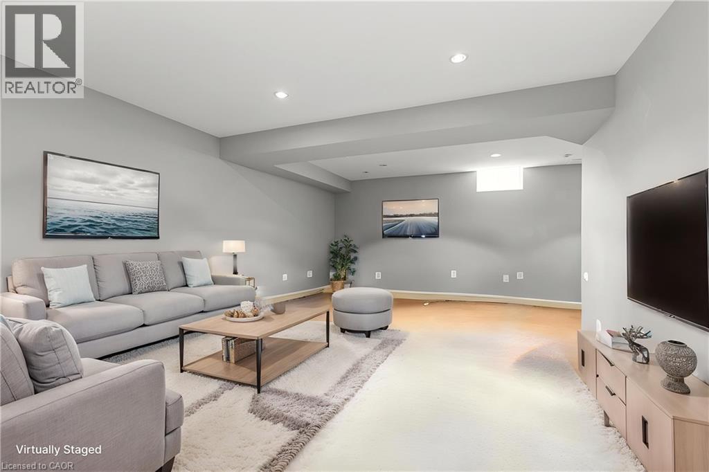 Recessed lighting, light gray wall finishes, wood-finish flooring, and a window well create a versatile living space - 2248 Seton Crescent, Burlington, ON - Indoor Photo Showing Living Room