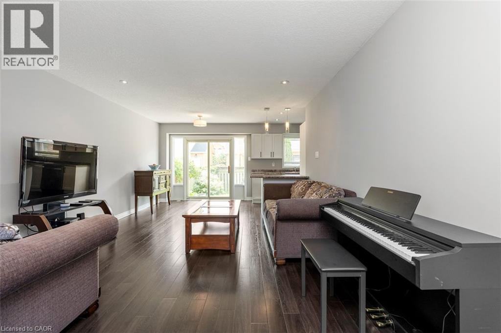 Open-concept living area featuring dark wood-finish flooring, light gray walls, and recessed ceiling lighting - 2248 Seton Crescent, Burlington, ON - Indoor Photo Showing Living Room