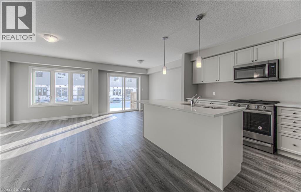 Open-concept living space featuring wood-finish flooring, a contemporary kitchen, and ample natural light - 44 Harrison Drive, Cambridge, ON - Indoor Photo Showing Kitchen
