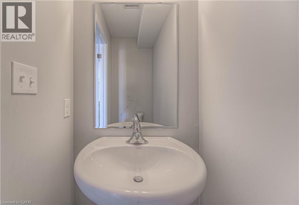 Pedestal sink with a chrome faucet set against light gray walls - 44 Harrison Drive, Cambridge, ON - Indoor Photo Showing Bathroom