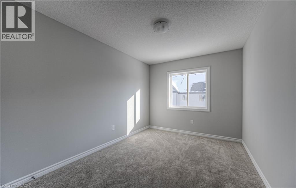 Neutral gray walls with white baseboards frame a window with white trim - 44 Harrison Drive, Cambridge, ON - Indoor Photo Showing Other Room