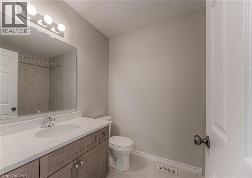 Bathroom featuring a wood-finish vanity with a light-colored countertop and integrated sink - 44 Harrison Drive, Cambridge, ON - Indoor Photo Showing Bathroom