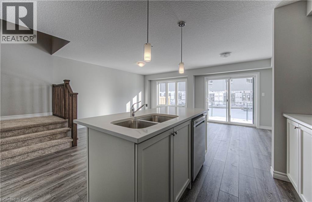 Kitchen island featuring a dual basin sink and polished chrome faucet - 44 Harrison Drive, Cambridge, ON - Indoor Photo Showing Kitchen With Double Sink