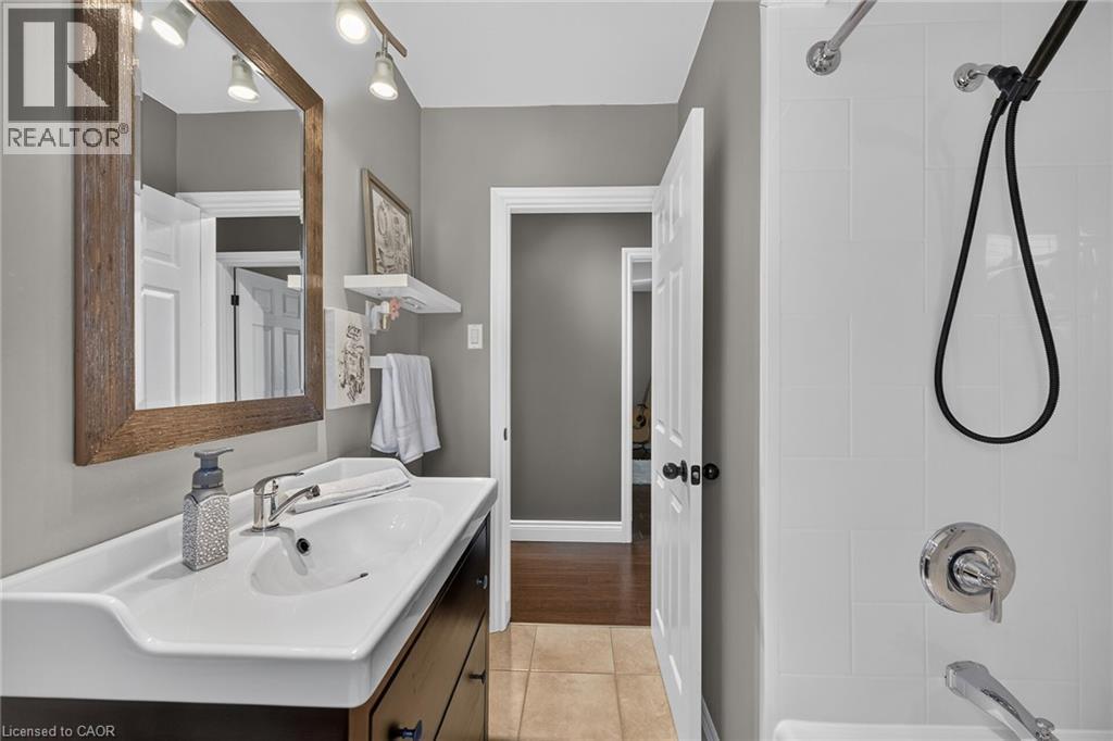 Bathroom featuring a vanity with an integrated sink, a large framed mirror, and track lighting - 386 Upper Kenilworth Avenue, Hamilton, ON - Indoor Photo Showing Bathroom