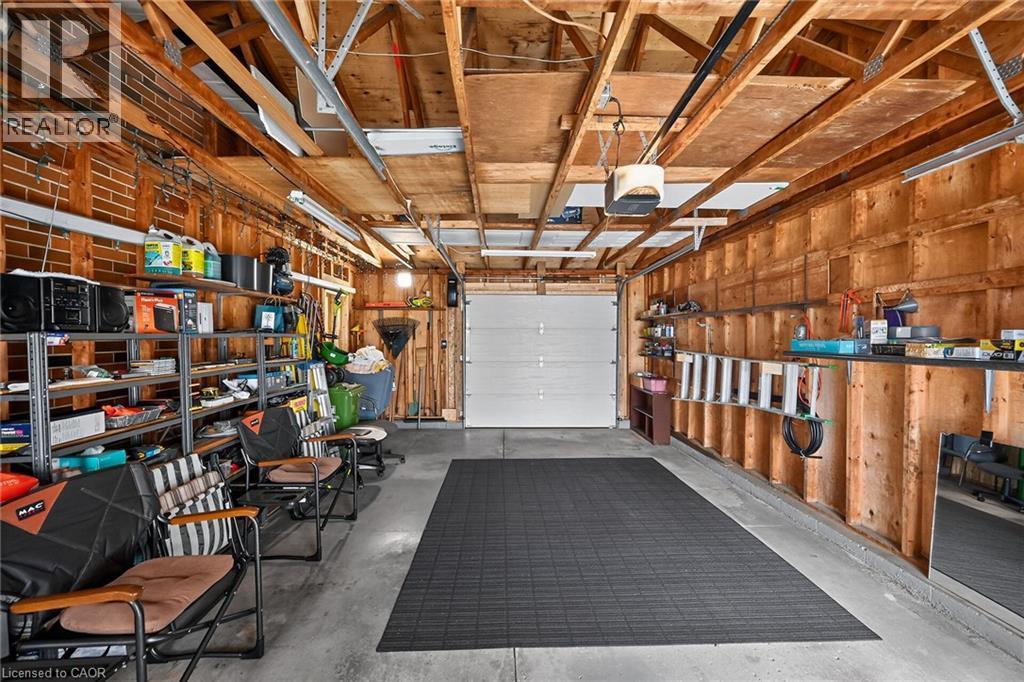 Spacious garage featuring concrete flooring and exposed wood ceiling joists - 386 Upper Kenilworth Avenue, Hamilton, ON - Indoor Photo Showing Garage