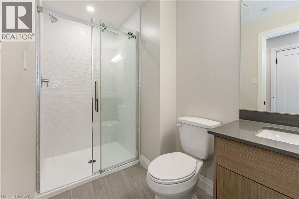 Contemporary bathroom featuring a walk-in shower with subway tile surround, sliding glass door, and integrated shower bench - 72 Erb Street E Unit# 103, Waterloo, ON - Indoor Photo Showing Bathroom