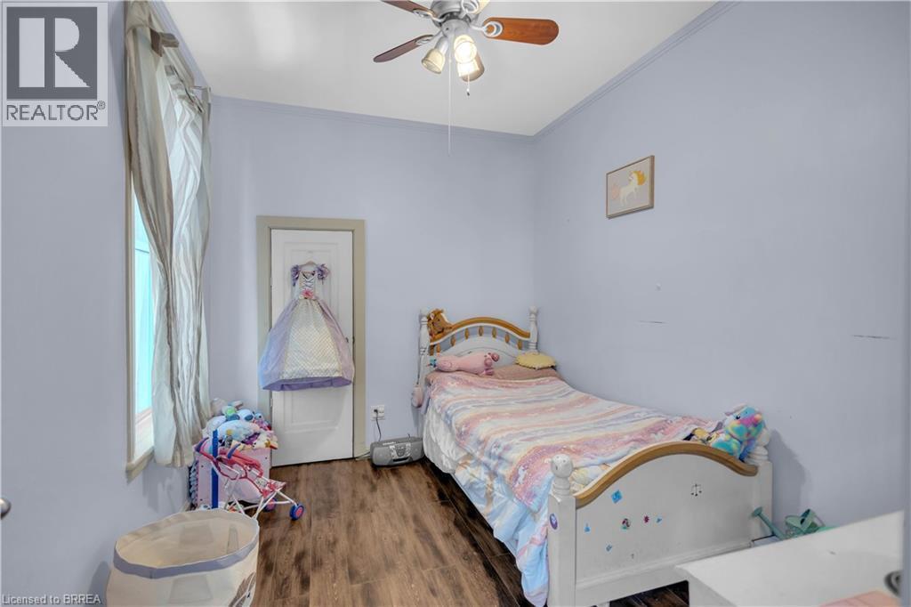 Interior room featuring wood-finish flooring, light blue wall paint, and a ceiling fan with integrated lighting - 17 Scarfe Avenue, Brantford, ON - Indoor Photo Showing Bedroom