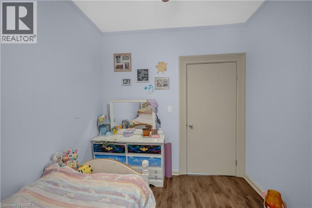 Light blue walls with crown molding and wood-finish flooring - 17 Scarfe Avenue, Brantford, ON - Indoor Photo Showing Bedroom
