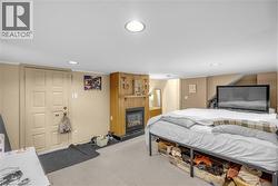 Carpeted room featuring a fireplace with a wood mantel and paneling, recessed lighting, and a six-panel door -