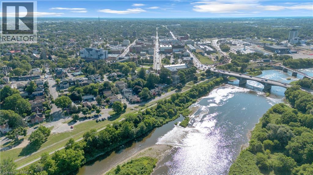 Aerial perspective showcasing a riverfront urban landscape with extensive tree canopy - 17 Scarfe Avenue, Brantford, ON - Outdoor With View