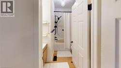 Bathroom featuring a white shower curtain, black shower fixtures, and white tiled bath surround -