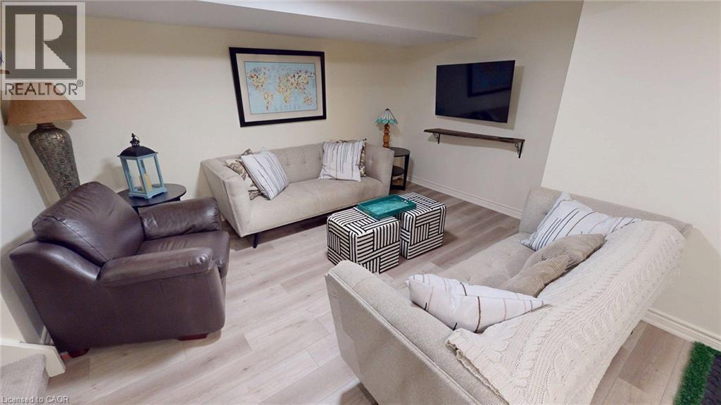 Recreation space featuring light wood-finish flooring, neutral wall tones, and a wall-mounted entertainment shelf - 4101 Diana Park, Vineland, ON - Indoor Photo Showing Living Room