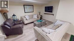 Recreation space featuring light wood-finish flooring, neutral wall tones, and a wall-mounted entertainment shelf -