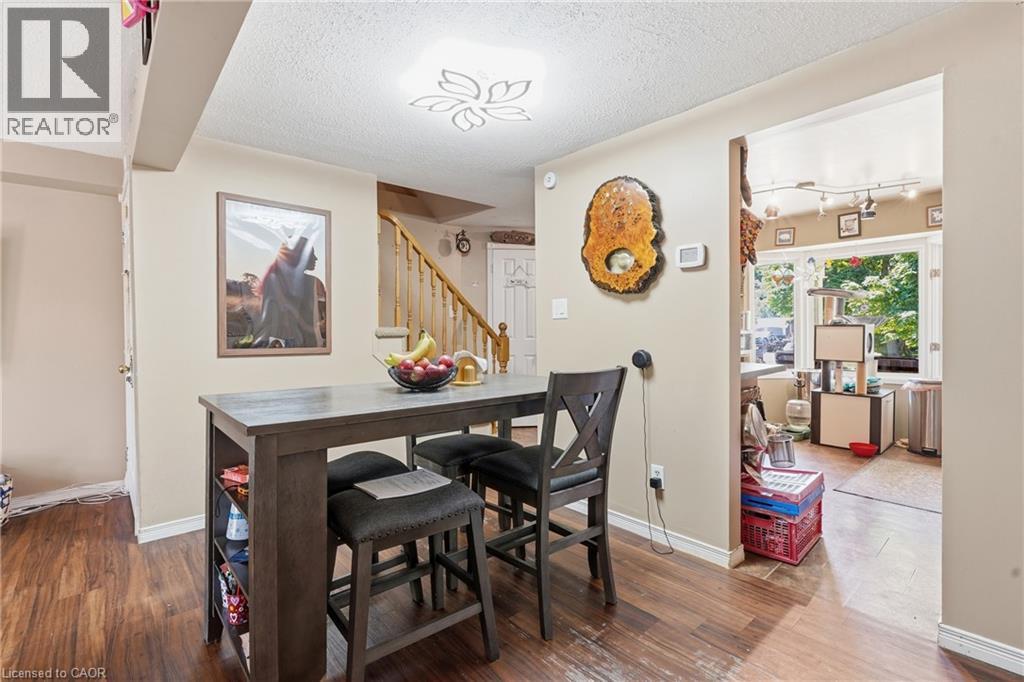 Dining area featuring wood-finish flooring and a built-in light fixture - 292 Mayview Court Unit# B, Waterloo, ON - Indoor Photo Showing Dining Room