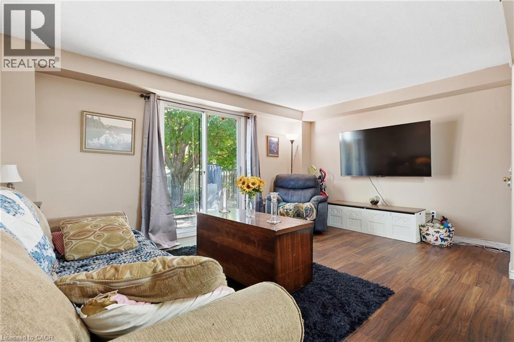 Living space featuring wood-finish flooring, light neutral wall tones, and recessed ceiling details - 292 Mayview Court Unit# B, Waterloo, ON - Indoor