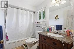Bathroom featuring a full vanity with a stone-finish countertop, undermount sink, and dark wood-finish cabinetry -