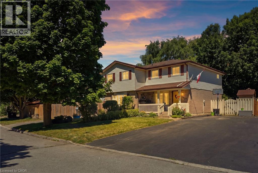 Two-story colonial with welcoming front elevation featuring a covered entry porch, multi-pane windows with warm interior lighting, and a professionally paved driveway - 292 Mayview Court Unit# B, Waterloo, ON - Outdoor