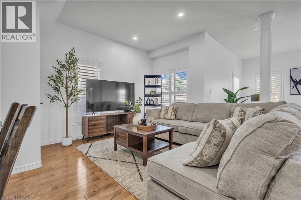 Open-concept living area featuring hardwood flooring, white walls, recessed lighting, and plantation shutters - 73 Fitzgerald Drive, Cambridge, ON - Indoor Photo Showing Living Room