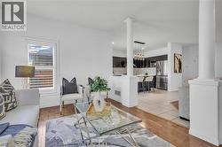 Open-concept living space with warm wood-finish flooring extending into the living area -