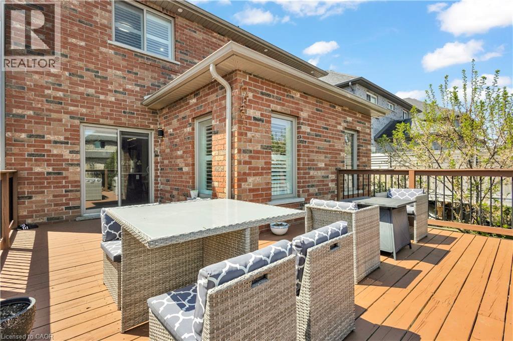 Expansive wood-finish deck with dark wood-finish railings, offering direct access to the interior via a sliding glass door - 73 Fitzgerald Drive, Cambridge, ON - Outdoor With Deck Patio Veranda With Exterior