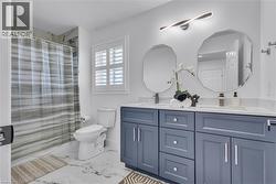 Bathroom featuring a double vanity with blue cabinetry, dual octagonal mirrors, and a white countertop -