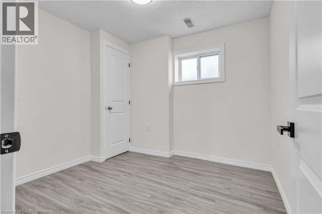 Neutral-toned room featuring light wood-finish flooring, white walls, and a single window - 73 Fitzgerald Drive, Cambridge, ON - Indoor Photo Showing Other Room