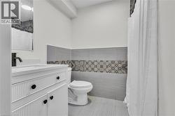 Bathroom featuring a white vanity with fluted detailing, black hardware, and a single-hole faucet -