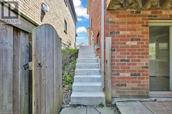 Brick exterior with concrete stairs accessing an upper level -