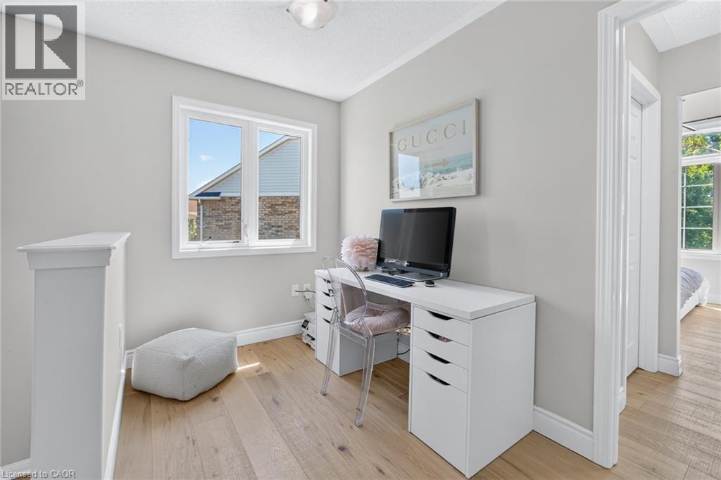 Bright interior space featuring light wood-finish flooring, a double window with white trim, and a white balustrade - 1533 Morse Place, Milton, ON - Indoor Photo Showing Office