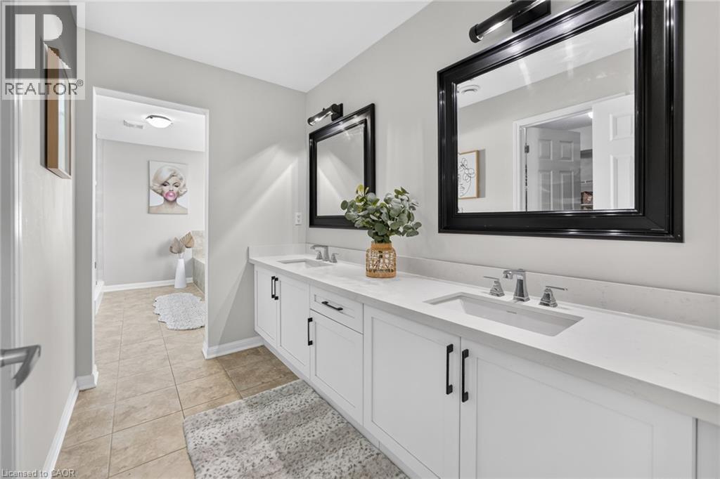 Dual vanity featuring white shaker-style cabinetry, chrome fixtures, and a light-toned countertop - 1533 Morse Place, Milton, ON - Indoor Photo Showing Bathroom