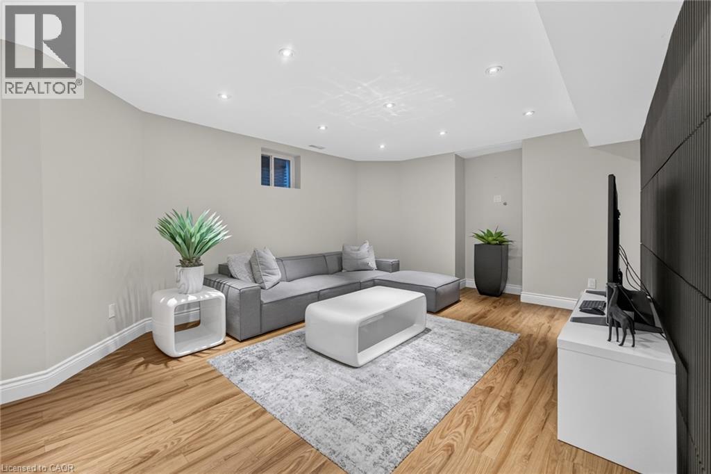Spacious room featuring wood-finish flooring, recessed lighting, and light-toned wall paint - 1533 Morse Place, Milton, ON - Indoor