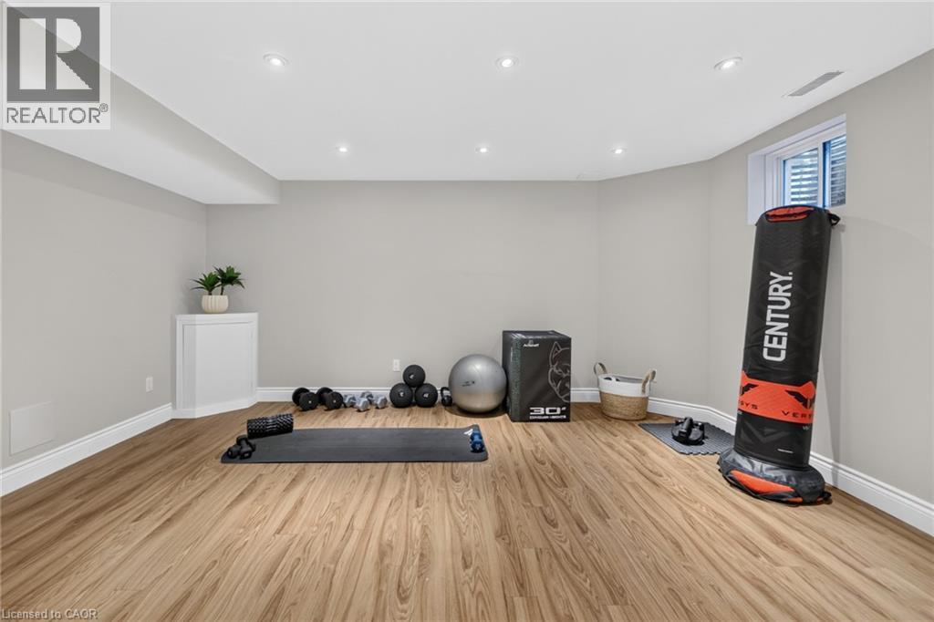 Spacious finished room featuring recessed lighting, light-toned walls, and wood-finish flooring - 1533 Morse Place, Milton, ON - Indoor