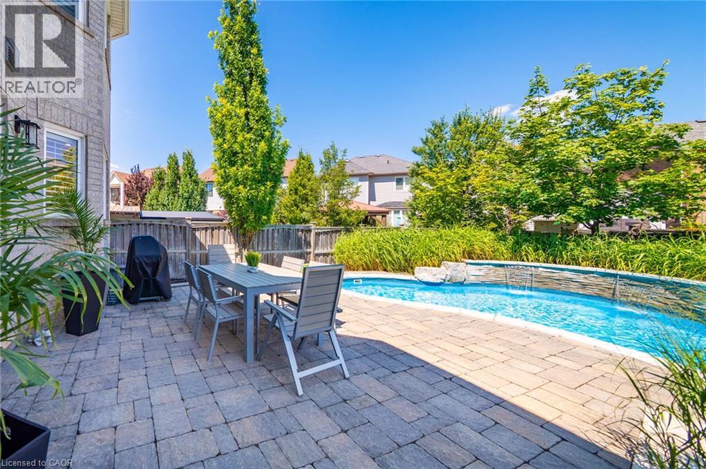 Expansive paver patio with an inground pool and water feature - 1533 Morse Place, Milton, ON - Outdoor With In Ground Pool With Deck Patio Veranda