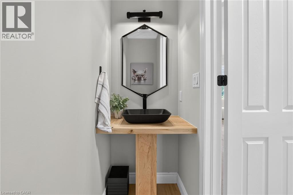 Modern vanity featuring a natural wood-finish countertop, a black vessel sink, and a matte black wall-mounted faucet - 1533 Morse Place, Milton, ON - Indoor Photo Showing Other Room
