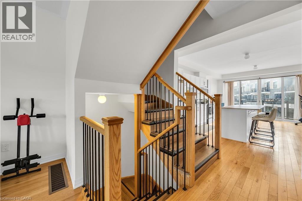 Hardwood staircase with natural wood handrails and black metal balusters - 1451 Green Road, Bowmanville, ON - Indoor Photo Showing Other Room