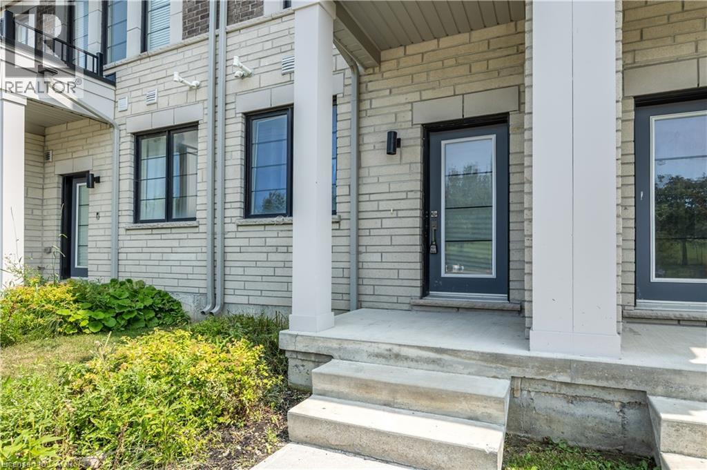 Light brick facade with dark-framed windows and a covered entrance featuring a glass-paneled door - 1451 Green Road, Bowmanville, ON - Outdoor