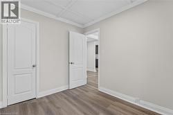 Neutral wall paint with crown molding and wood-finish flooring -