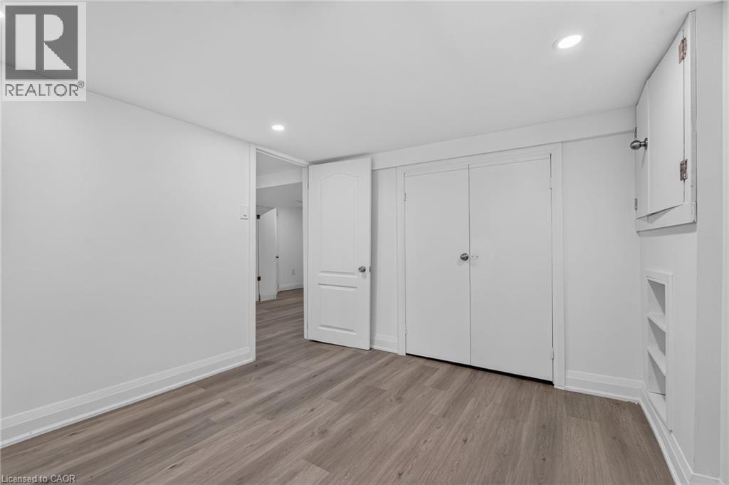 Light wood-finish flooring complements the neutral wall tones - 36 Mahony Avenue, Hamilton, ON - Indoor Photo Showing Other Room