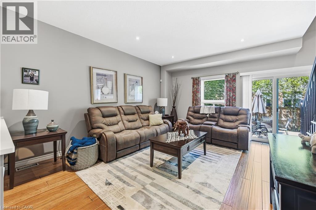 Open concept living area featuring light gray walls, recessed lighting, and wood-finish flooring - 10 Kopperfield Lane, Hamilton, ON - Indoor Photo Showing Living Room
