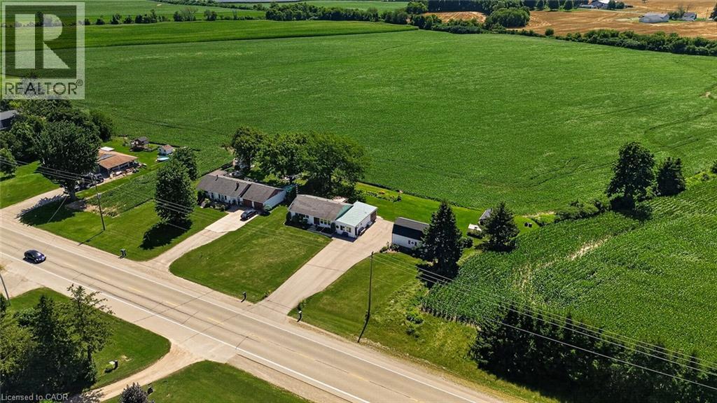 Expansive property featuring a paved road frontage, mature trees, and multiple structures - 184726 Cornell Road, Tillsonburg, ON - Outdoor With View