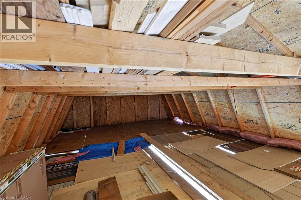 Unfinished attic space featuring exposed wood framing, oriented strand board walls, and visible insulation - 184726 Cornell Road, Tillsonburg, ON - Indoor Photo Showing Other Room