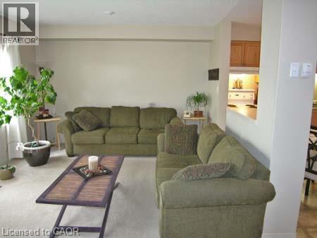 Living area featuring light-toned wall finishes and carpeting - 151 Clairfields Drive E Unit# 39, Guelph, ON - Indoor Photo Showing Living Room