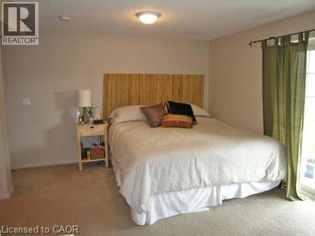 Bedroom featuring neutral wall paint, a ceiling-mounted light fixture, and beige carpeting - 151 Clairfields Drive E Unit# 39, Guelph, ON - Indoor Photo Showing Bedroom