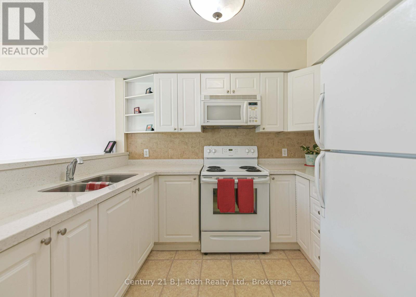 Lots of counters space and cupboards - Unit 201 - 115 Bond Street, Orillia, ON - Indoor Photo Showing Kitchen With Double Sink