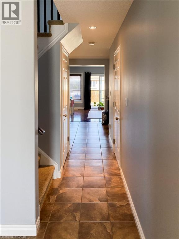 Inviting hallway featuring neutral wall tones and square tile flooring - 180 Huck Crescent, Kitchener, ON - Indoor Photo Showing Other Room