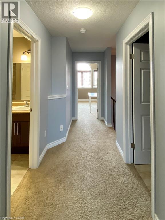 Carpeted hallway featuring light blue walls, white trim, and a flush mount ceiling light - 180 Huck Crescent, Kitchener, ON - Indoor Photo Showing Other Room