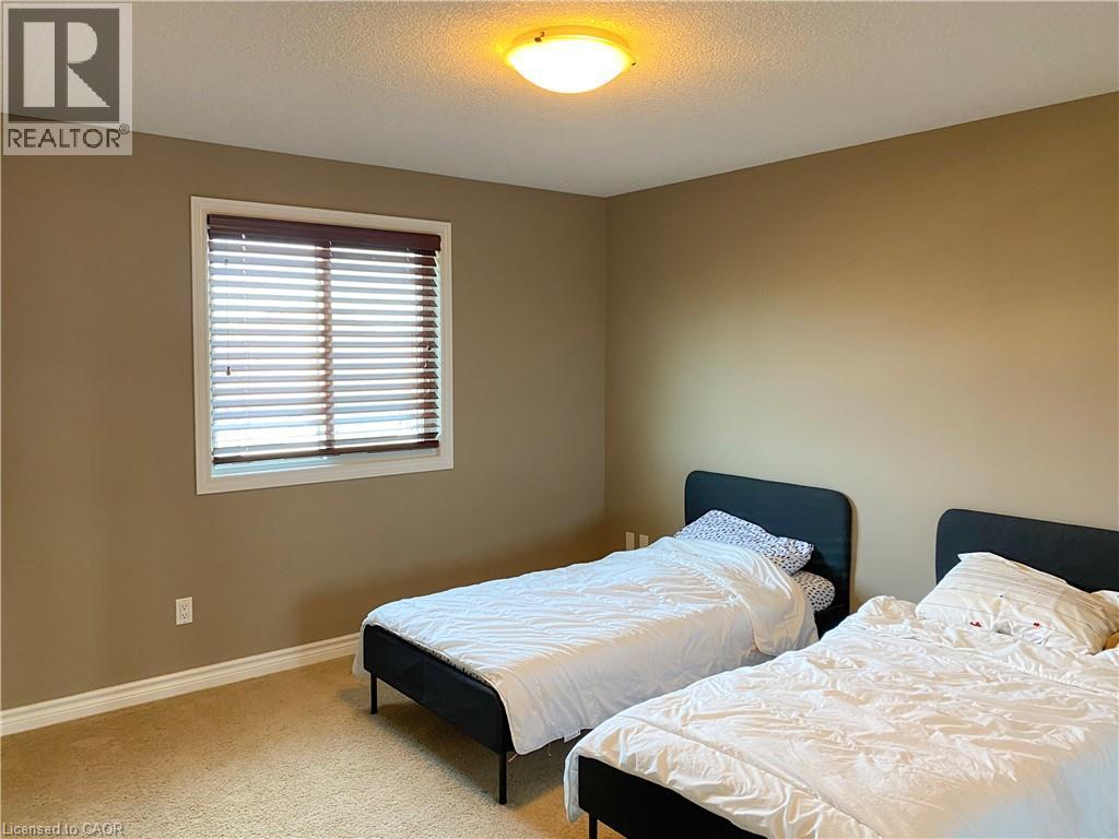 Neutral tone wall paint with white trim, carpeting, and a window featuring horizontal blinds - 180 Huck Crescent, Kitchener, ON - Indoor Photo Showing Bedroom