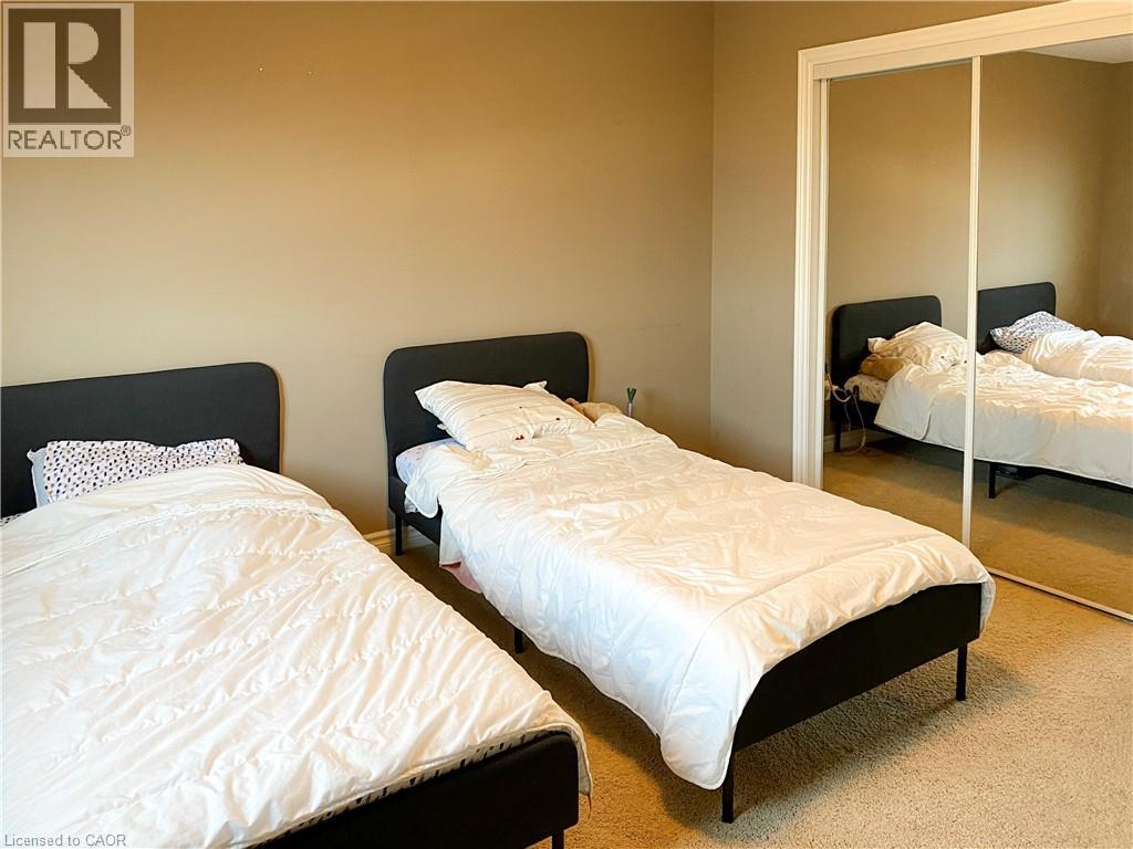 Bedroom featuring neutral wall paint, light-colored carpet flooring, and a mirrored closet with white trim - 180 Huck Crescent, Kitchener, ON - Indoor Photo Showing Bedroom