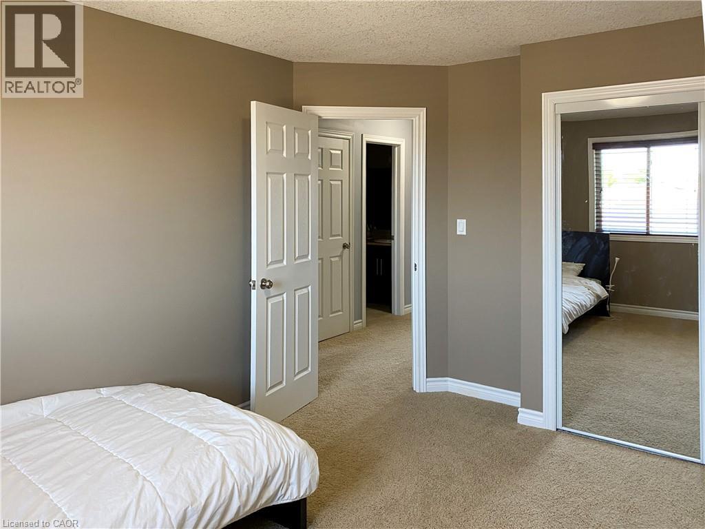 Carpeted room with neutral-toned walls, white trim, and a textured ceiling - 180 Huck Crescent, Kitchener, ON - Indoor Photo Showing Bedroom