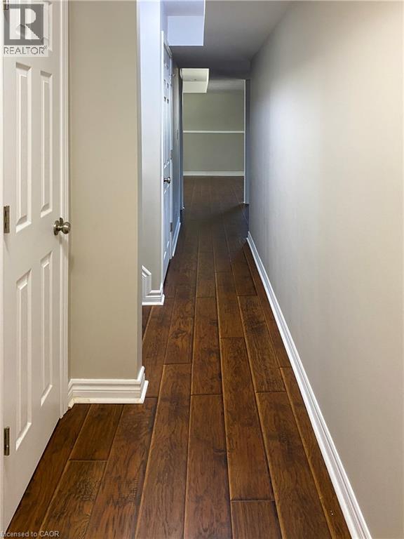 Hallway with wood-finish flooring, white baseboards, and light neutral wall paint - 180 Huck Crescent, Kitchener, ON - Indoor Photo Showing Other Room